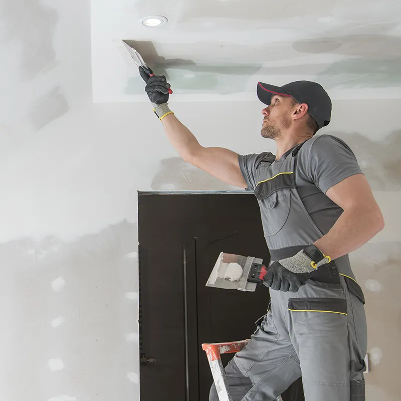 Worker Installing and Spackling Sheetrock | In and Out Flooring